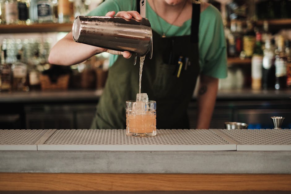 Bartender pouring vibrant cocktails at an event